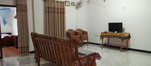 a room with chairs and a television and a table at Akshaya Rest Maskeliya in Nikawatawana