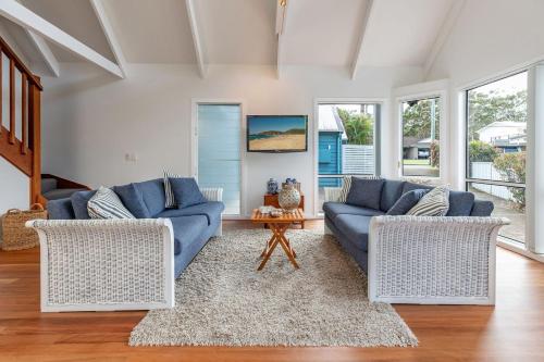 a living room with two blue couches and a table at Twin Peaks 2 in Blueys Beach