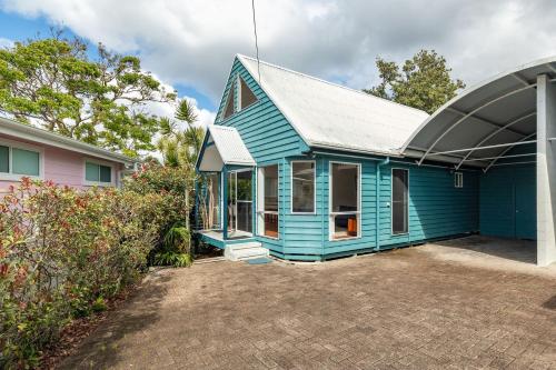 a blue house with a grey roof at Twin Peaks 2 in Blueys Beach
