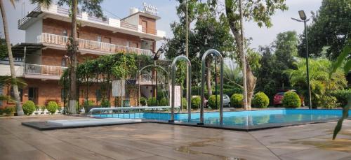 a swimming pool in front of a building at DOLPHIN ENCLAVE SERVICE STUDIO APARTMENTS in Kalpetta