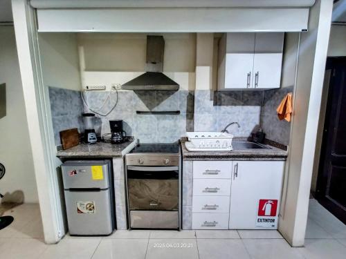a small kitchen with a stove and a sink at Departamento entero de 3 dormitorios en urbanización privada con garaje y seguridad 24h in Guayaquil