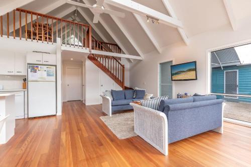 a living room with two blue couches and a staircase at Twin Peaks 2 in Blueys Beach