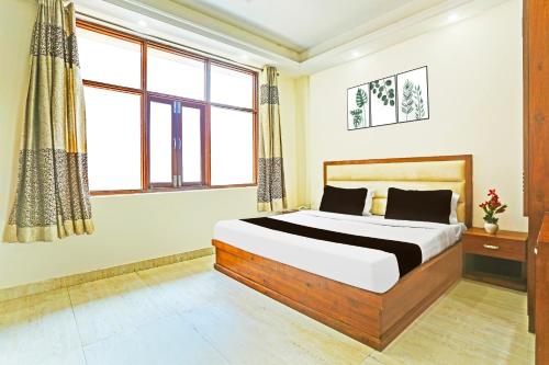 a bedroom with a bed and a window at Super Hotel O Gurgaon Old Town in Gurgaon