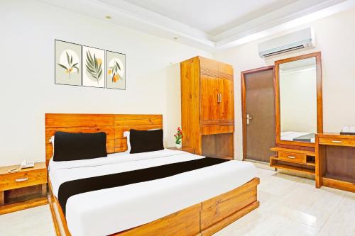 a bedroom with a large bed and a television at Super Hotel O Gurgaon Old Town in Gurgaon