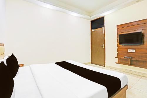 a bedroom with a white bed and a tv at Super Hotel O Gurgaon Old Town in Gurgaon