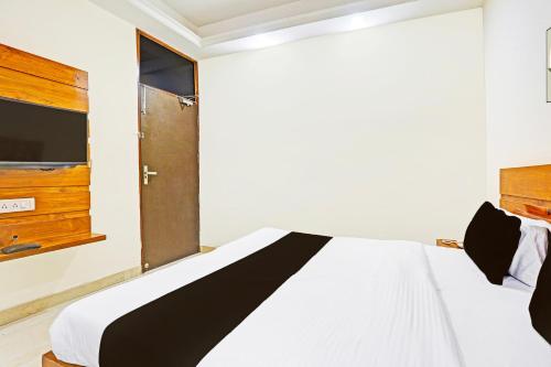 a bedroom with a white bed and a window at Super Hotel O Gurgaon Old Town in Gurgaon