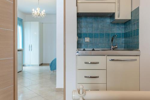 a kitchen with white cabinets and a sink at Kallisti Studios in Naxos Chora