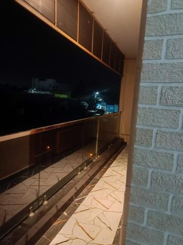a balcony with a view of a city at night at Little Hearts recidency in Āvadi