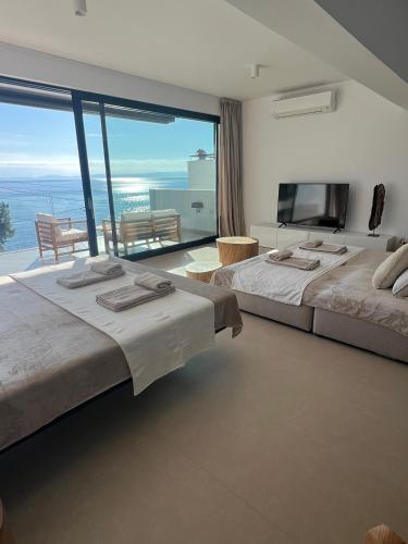two beds in a room with a large window at Apartments-M4 in Neos Marmaras
