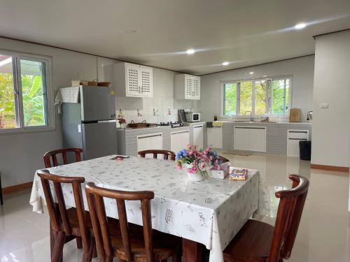 a kitchen with a table and chairs and a kitchen with a refrigerator at Happy Farm Home stay Khaoyai in Ban Nong Khwang