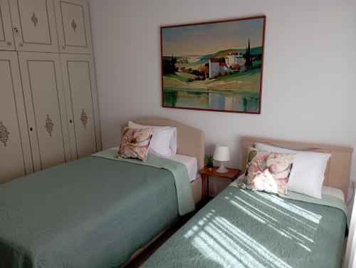 Un dormitorio con dos camas y un cuadro en la pared. en Walnuthouse, en Dhíkella