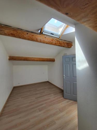 Cette chambre mansardée dispose d'une lucarne et d'une porte. dans l'établissement Villa du canton vert, à Plan-de-Cuques