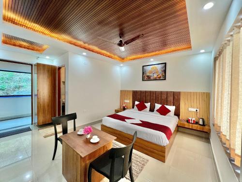 a bedroom with a bed and a desk and a table at Dhurva Hotel and Resort in Naugaon