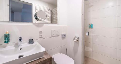 a white bathroom with a sink and a toilet at Aiden by Best Western Biberach in Biberach an der Riß