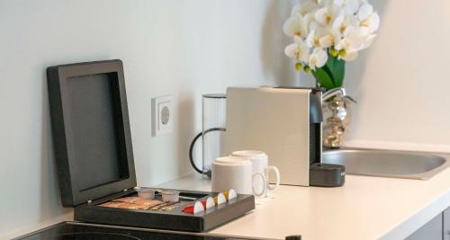 a counter top with a computer monitor and a coffee mug at Aiden by Best Western Biberach in Biberach an der Riß