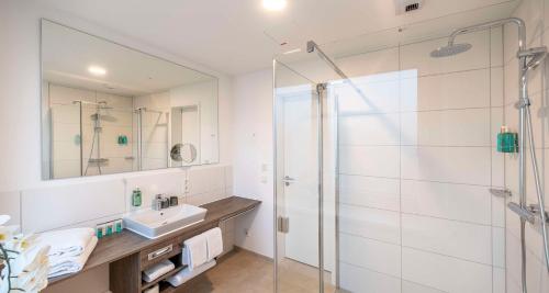 a bathroom with a shower and a sink at Aiden by Best Western Biberach in Biberach an der Riß