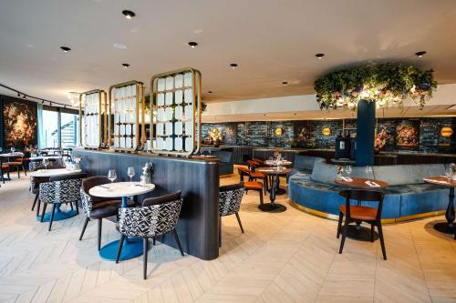 a restaurant with tables and chairs and a bar at DoubleTree by Hilton Royal Parc Soestduinen in Amersfoort