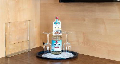 a bottle of alcohol and two wine glasses on a table at Sure Hotel by Best Western Hilden-Düsseldorf in Hilden