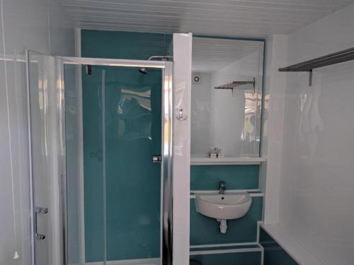 a bathroom with a sink and a glass shower at Mayfair Hotel - Isle Of Wight in Shanklin