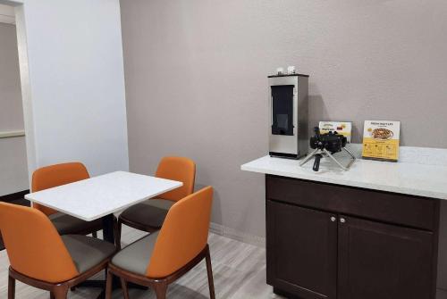 a waiting room with a table and orange chairs at Baymont by Wyndham San Antonio Airport in San Antonio