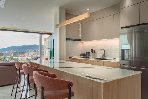 a kitchen with a counter with bar stools at Luxury Seaview Villa in Patong - Villa Yona in Patong Beach