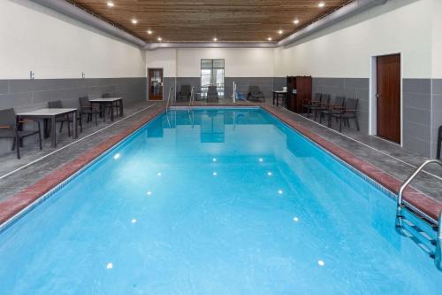 a large swimming pool with tables and chairs at La Quinta Inn & Suites by Wyndham Coralville Iowa City in Coralville