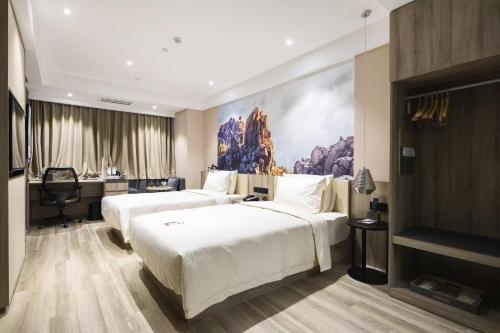 a hotel room with two beds and a desk at Atour Hotel Qingdao Tangdao Bay National Wetland Park in Qingdao