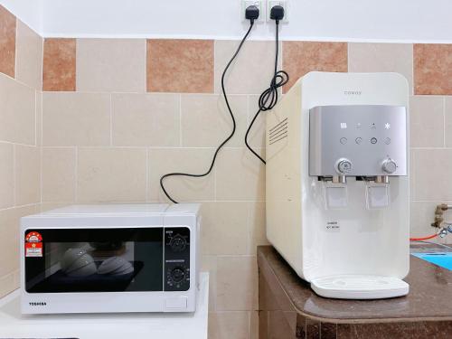 a microwave sitting on a counter next to a coffee maker at 12Pax BM 大山脚 Double-storey Autocity Alma Aeonjusco in Bukit Mertajam
