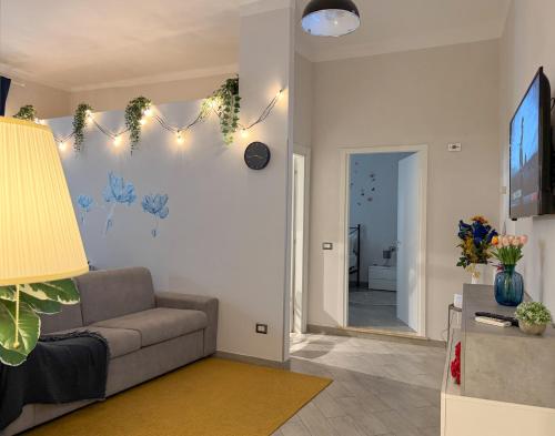 a living room with a couch and a television at AGATHEA APARTMENT - Central Location, Just 50m from the Sea - Nettuno in Nettuno