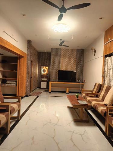a living room with a couch and a tv at Little Hearts in Chennai