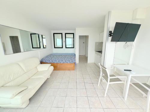 - un salon blanc avec un canapé et un lit dans l'établissement Studio 26C, Bat C Héliopolis Village Naturiste, au Cap d'Agde