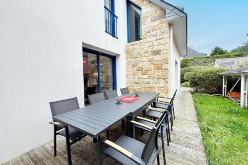 une table et des chaises en bois sur une terrasse dans l'établissement Charmante maison bord de mer - 100m des plages, à l'Île-Tudy