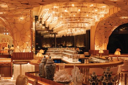a restaurant with a bar with chandeliers and vases at Jumeirah Marsa Al Arab Dubai in Dubai