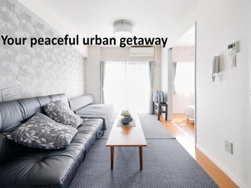 a living room with a couch and a coffee table at Nakano Apartment hotel in Tokyo