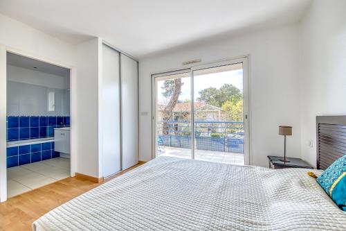 Un dormitorio con una cama grande y una ventana grande. en 3 pièces - Piscine - Proche plage, en Soulac-sur-Mer