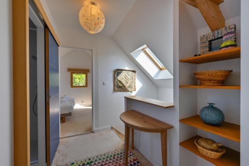 Cette chambre dispose d'un escalier avec une table et des étagères. dans l'établissement L'Annëxe de Kerogile - Avec jardin et terrasse, à Carnac