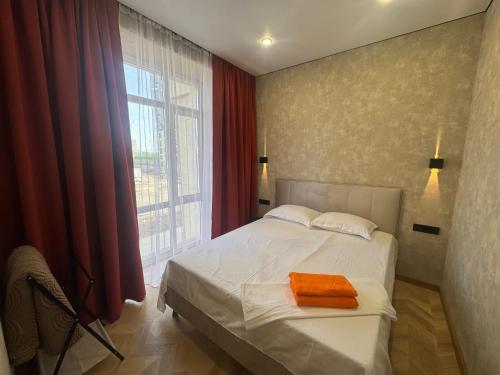 a bedroom with a bed with an orange towel on it at Байсанат 1 in Zhezdi