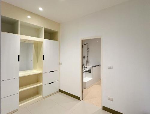 a bathroom with white cabinets and a walk in shower at Phitsanulok United Hotel in Ban Wat Chan