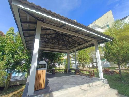 a pergola with a bench on a patio at Homelite Eco Park Condominium in Miri