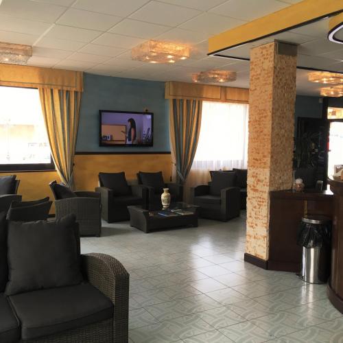 a waiting room with couches and a flat screen tv at Hotel Don Pedro in Portoscuso