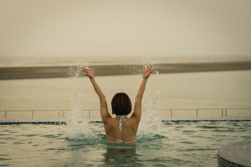 a woman in the water with her arms in the water at THE SENAGAJIMA STORYLINE in Tomigusuku