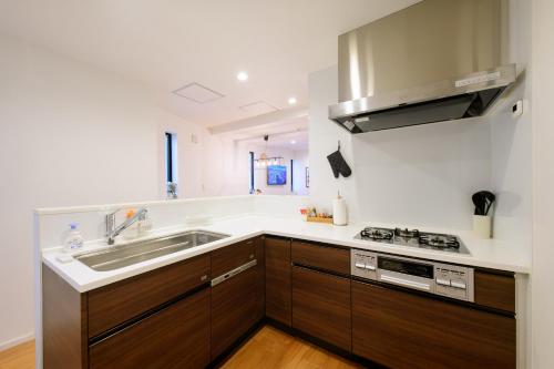 a kitchen with a sink and a stove at Sangen-jaya House-O in Tokyo