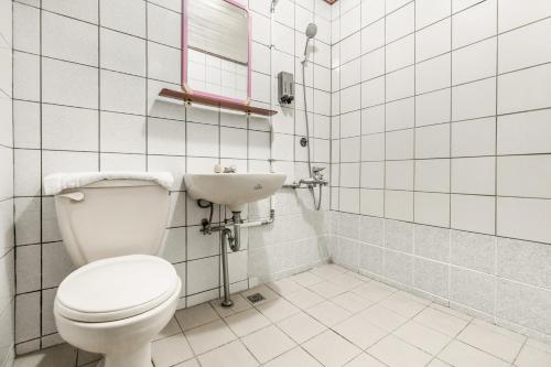 a white bathroom with a toilet and a sink at Forever Happiness Hostel in Puli