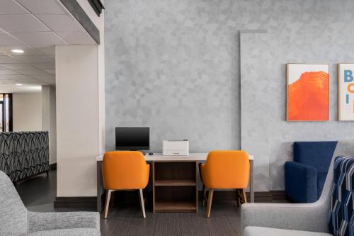 an office with a desk with two chairs and a computer at Holiday Inn Express Hotel & Suites Bentonville by IHG in Bentonville