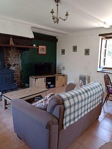 a living room with a couch and a fireplace at Rustic cottage full of charm for the perfect getaway in Normandy in Pontfarcy