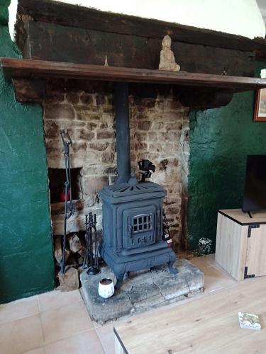 a fireplace in a living room with a stove at Rustic cottage full of charm for the perfect getaway in Normandy in Pontfarcy