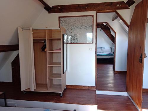 an attic room with a refrigerator and a door at Rustic cottage full of charm for the perfect getaway in Normandy in Pontfarcy