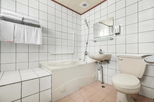 a white bathroom with a toilet and a sink at Forever Happiness Hostel in Puli