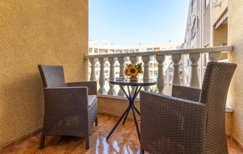 a balcony with two chairs and a table with flowers on it at Gorgeous Apartment In Torrevieja in Torrevieja