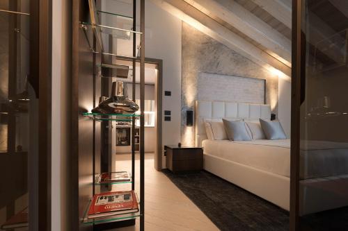a bedroom with a white bed and a mirror at Ca' Apollonio Heritage in Romano D'Ezzelino